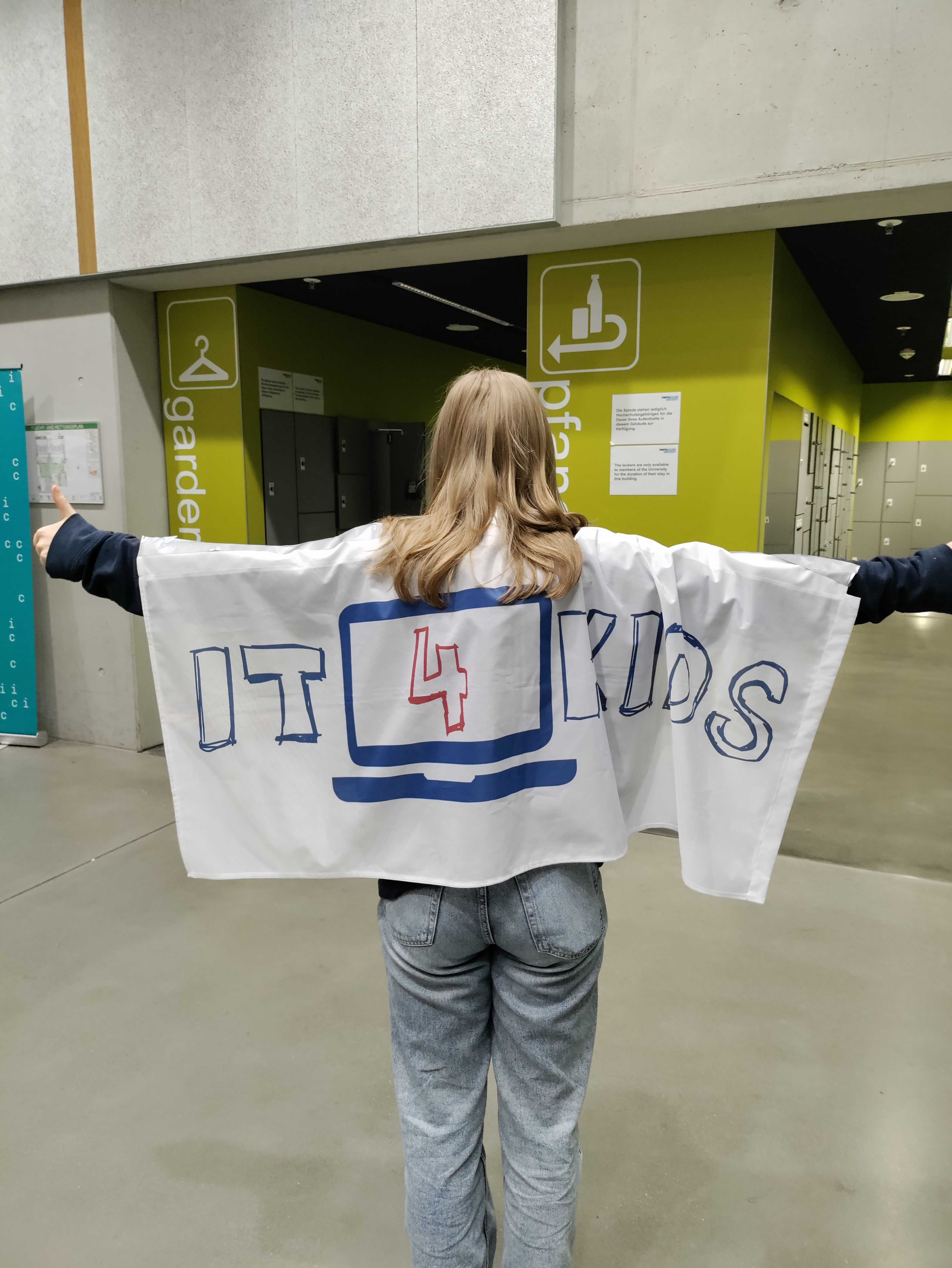 Teammitglied von hinten mit einer IT4Kids-Flagge