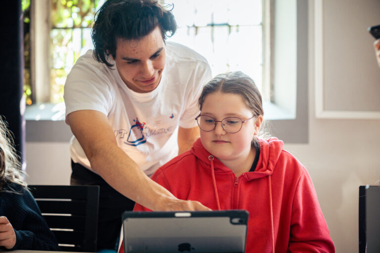 IT4Kids-Teamer hilft Teilnehmerin beim Programmieren